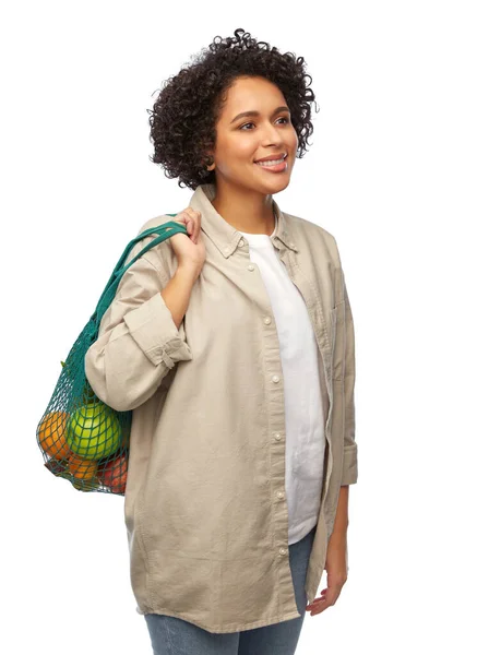 Улыбающаяся женщина с едой в многоразовой струнной сумке — стоковое фото