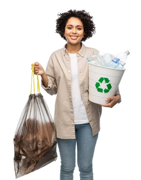 Улыбающаяся женщина сортирует пластиковые и бумажные отходы — стоковое фото