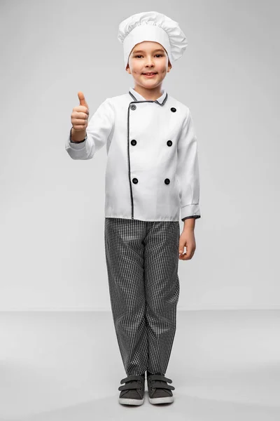 Malý chlapec v kuchařské toque ukazující palce nahoru — Stock fotografie
