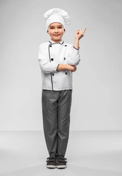 Malý chlapec v kuchařské toque ukazující prstem nahoru — Stock fotografie