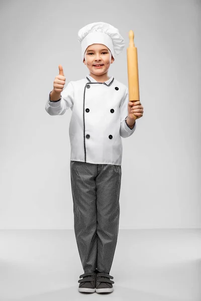 Мальчик-повар с булавкой показывает большие пальцы вверх — стоковое фото