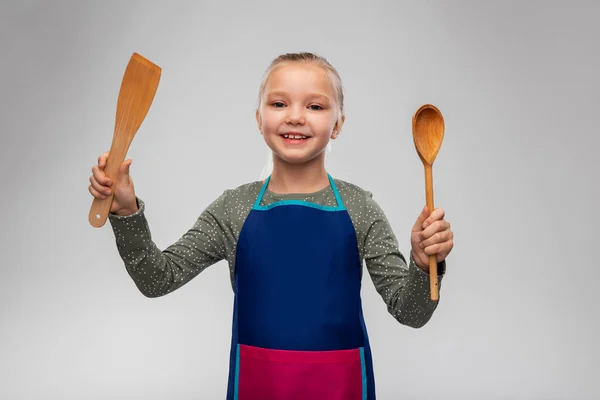 Boldog kislány kötényben kanállal és spatulával — Stock Fotó