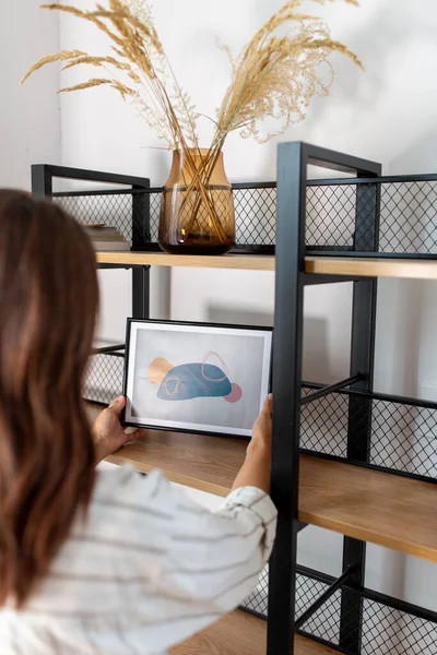 Vrouw versieren huis met foto in frame — Stockfoto