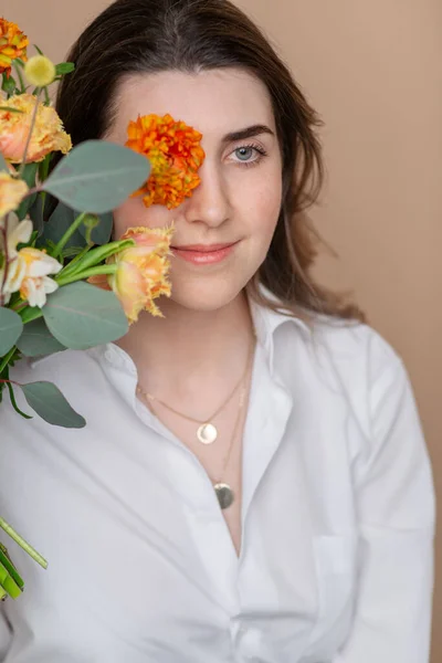 Portrait of pensive woman with bunch of flowers — Stock Photo, Image