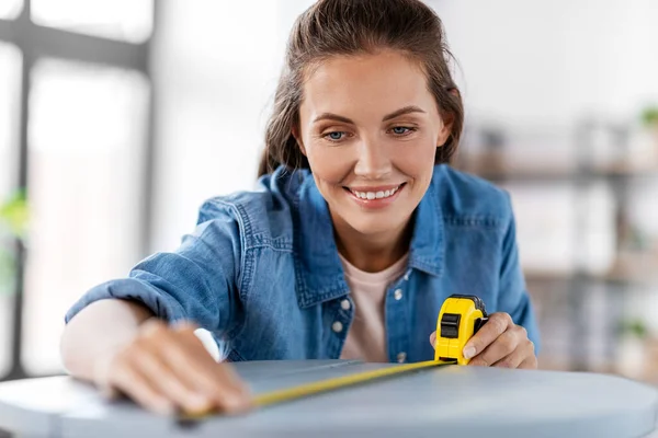 Woman with ruler measuring table for renovation — Stock Photo, Image