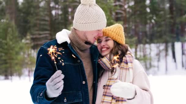 Щаслива пара з блискітками в зимовому лісі — стокове відео