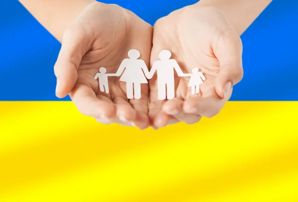 Mains tenant icône de la famille sur le drapeau de l'ukraine — Photo