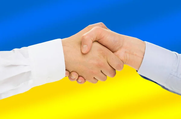Close up de aperto de mão sobre a bandeira de cores ucranianas — Fotografia de Stock