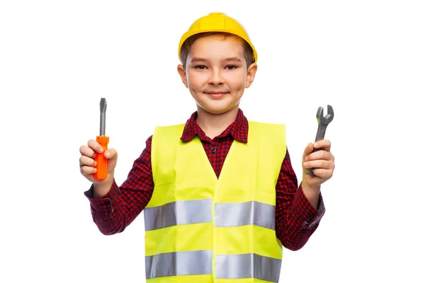 Pojke i byggnad hjälm med skruvmejsel och skiftnyckel — Stockfoto