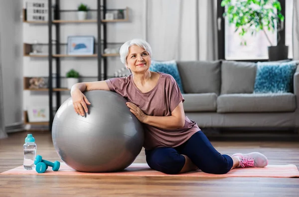 Usmívající se starší žena s cvičební míč doma — Stock fotografie
