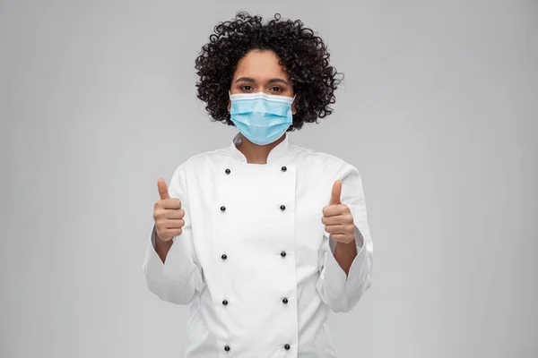 Vrouwelijke chef in medisch masker tonen duimen omhoog — Stockfoto