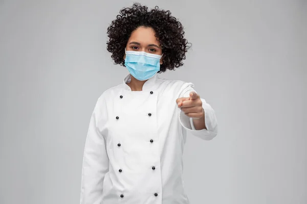 Vrouwelijke chef in medisch masker wijzend naar camera — Stockfoto