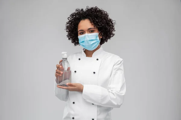 Vrouwelijke chef-kok in masker met handreiniger of zeep — Stockfoto