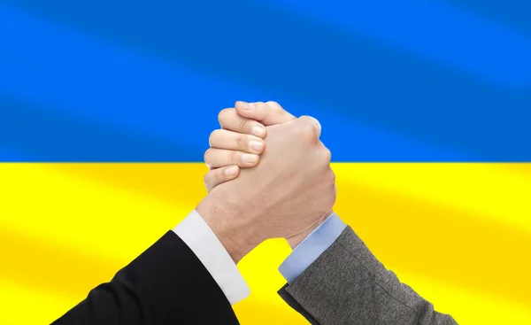 Nahaufnahme von Armdrücken über die Flagge der Ukraine — Stockfoto