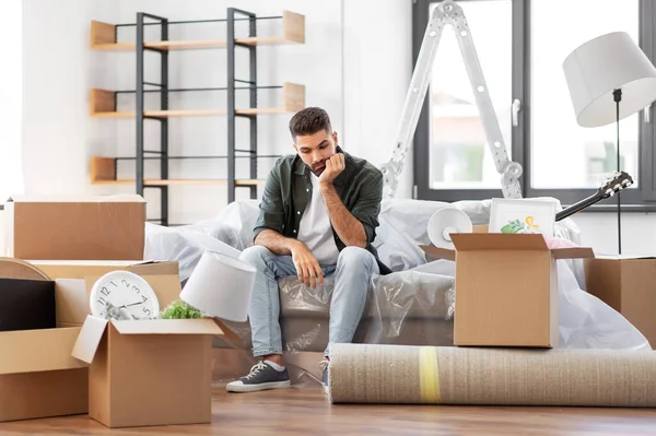 Sad man with boxes moving to new home — Stock Photo, Image