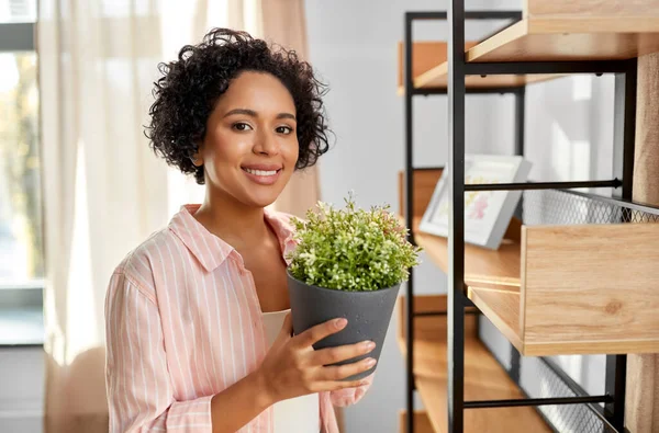 Kvinna dekorera hem med blomma eller krukväxt — Stockfoto