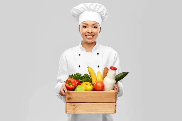 Chef feminino sorridente feliz com comida em caixa de madeira — Fotografia de Stock