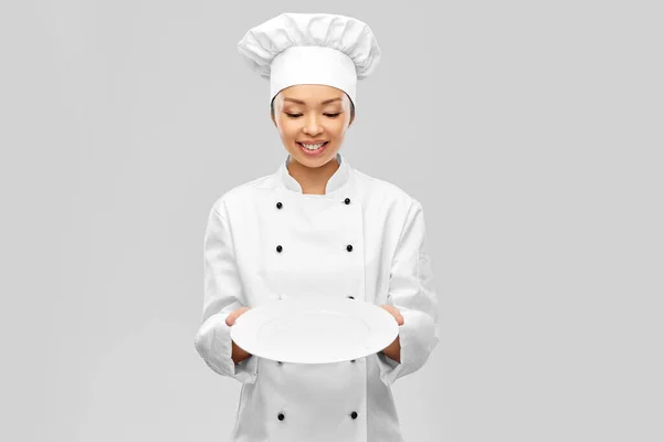 Feliz mujer sonriente chef sosteniendo plato vacío —  Fotos de Stock