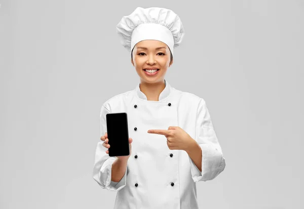 Glimlachende vrouwelijke chef met smartphone — Stockfoto