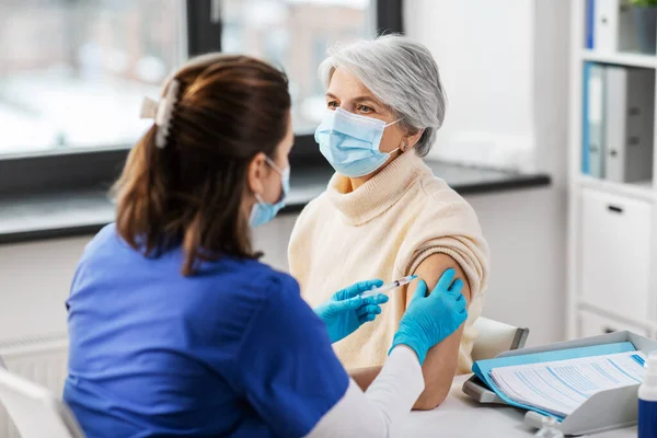 Verpleegkundige met injectiespuit die injectie toedient aan vrouw — Stockfoto