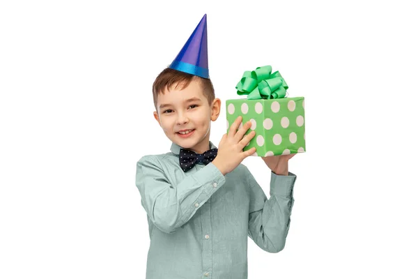 Menino sorridente em chapéu de festa com presente de aniversário — Fotografia de Stock