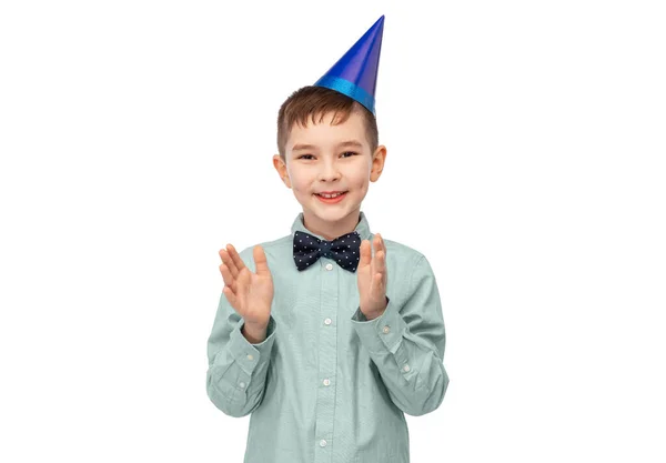 Smiling boy in birthday party hat clapping hands — Stock Photo, Image