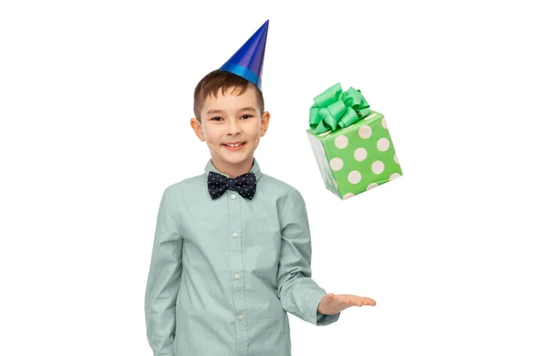 誕生日プレゼントとパーティーの帽子の笑顔の男の子 ストック画像