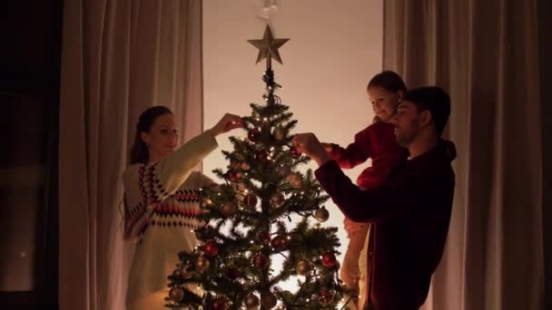 Ευτυχισμένη οικογένεια διακόσμηση χριστουγεννιάτικο δέντρο στο σπίτι — Αρχείο Βίντεο