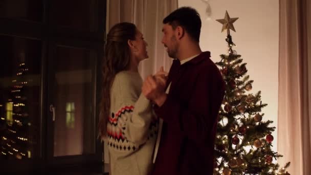 Ευτυχισμένο ζευγάρι που χορεύει κοντά στο χριστουγεννιάτικο δέντρο στο σπίτι — Αρχείο Βίντεο