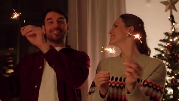 Happy couple with sparklers on christmas at home — Stock Video