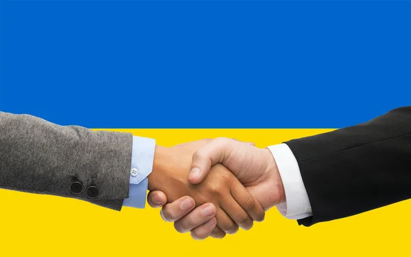 Primer plano del apretón de manos sobre la bandera de colores ucranianos —  Fotos de Stock