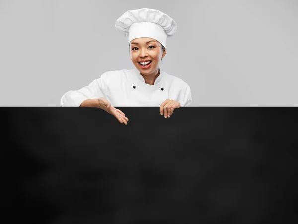 Lächelnde Köchin mit schwarzer Tafel — Stockfoto