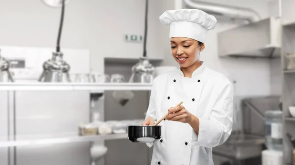 Gelukkig glimlachende vrouwelijke chef met steelpan — Stockfoto