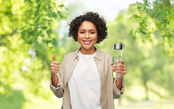 Mulher feliz com água potável em garrafa de vidro — Fotografia de Stock