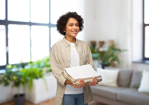 Mujer sonriente con revistas clasificando residuos de papel — Foto de Stock