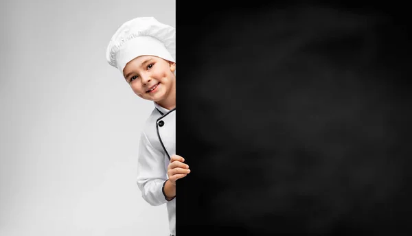 Happy little boy in chefs toque with chalkboard — Stock Photo, Image