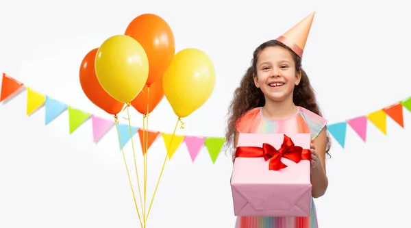 Menina sorridente em chapéu de festa com presente de aniversário — Fotografia de Stock