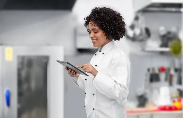 Chef sorridente che mostra tablet pc sulla cucina — Foto Stock