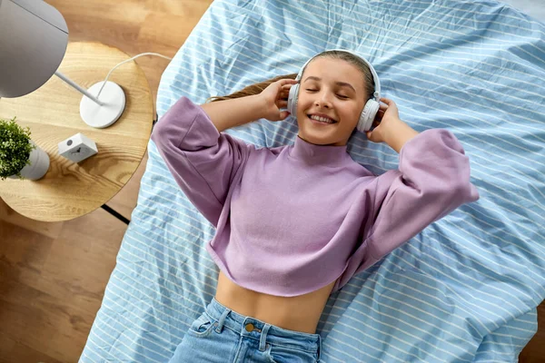 Chica en auriculares escuchando música en casa — Foto de Stock