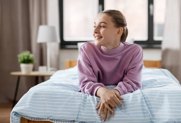 행복 한 미소짓는 소녀 가 집에서 침대에 누워 — 스톡 사진
