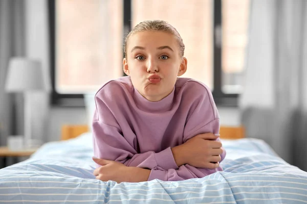 家のベッドに横になって顔を出す女の子 — ストック写真