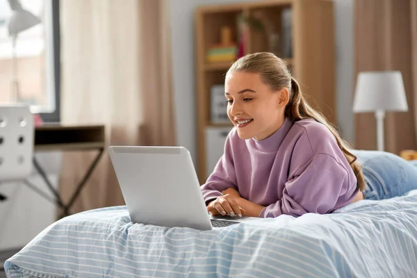 Chica sonriente con ordenador portátil en casa —  Fotos de Stock