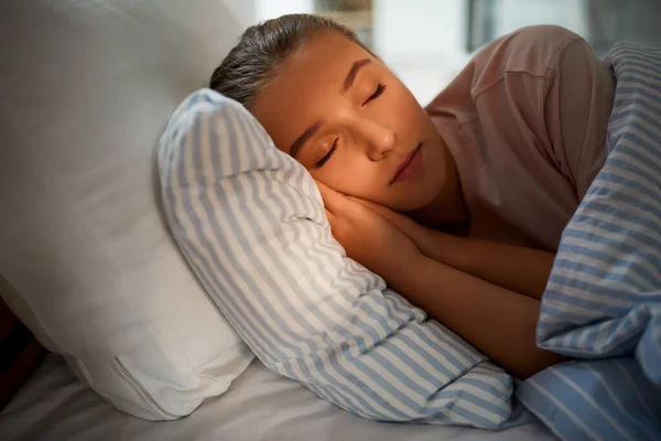 Девушка спит в постели дома — стоковое фото