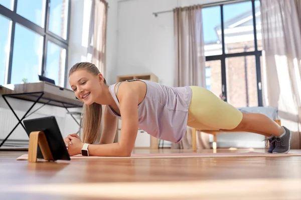 Εφηβική κοπέλα με tablet pc άσκηση στο σπίτι — Φωτογραφία Αρχείου