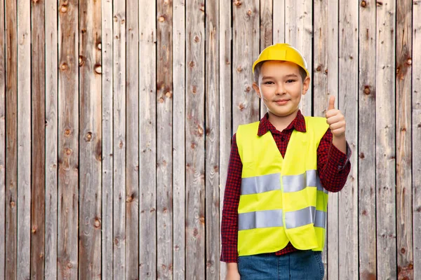 Szczęśliwy chłopiec w kask budowlany pokazując kciuki w górę — Zdjęcie stockowe
