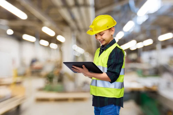 Menino em capacete de construção com tablet computador — Fotografia de Stock