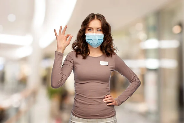 Gelukkig vrouw winkel assistent in medisch masker — Stockfoto