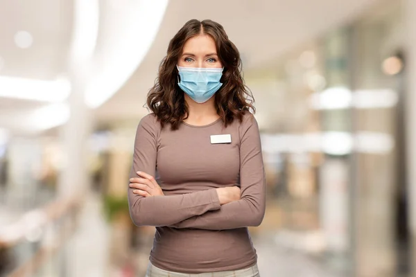 Gelukkig vrouw winkel assistent in medisch masker — Stockfoto