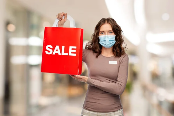 Vendedora em máscara com venda de palavras no saco de compras — Fotografia de Stock