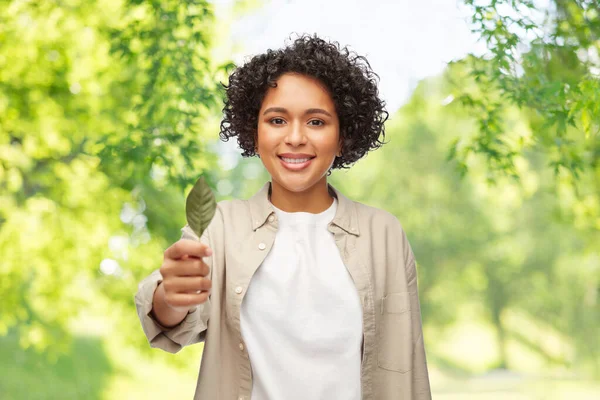 Sonriente mujer sosteniendo hoja verde —  Fotos de Stock